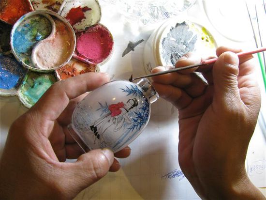 Diese Fläschchen werden mit einem um 90º abgewinkelten Haarpinsel von innen bemalt