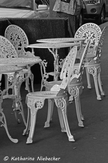 Altmodische Tische und Stühle eines Straßencafes.