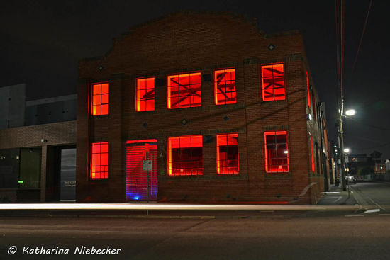 Ausnahme einer beleuchteten Halle mit weißen Lichtstreifen eines vorbeifahrenden Autos als Unterlegung.