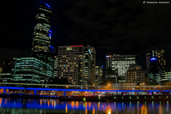 Blick auf die Rialto-Towers (links im Bild) und den westlichen Teil des CBD (Central Business District) mit seinen blau beleuchteten Bahngleisen im Vordergrund, welche sich im Yarra River widerspiegeln....