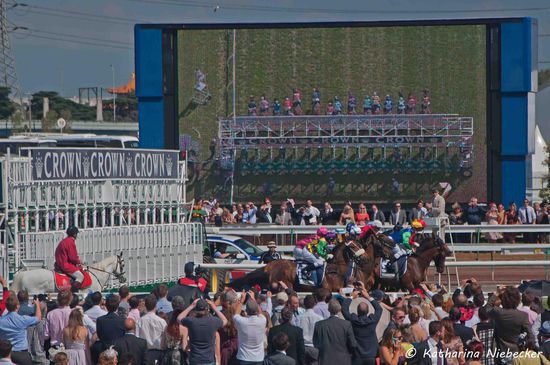 Im Hintergrund kann man eine der vielen großen Übertragungs-Leinwaände sehen.... mit Blick von oben aus dem Helikopter auf den Start...