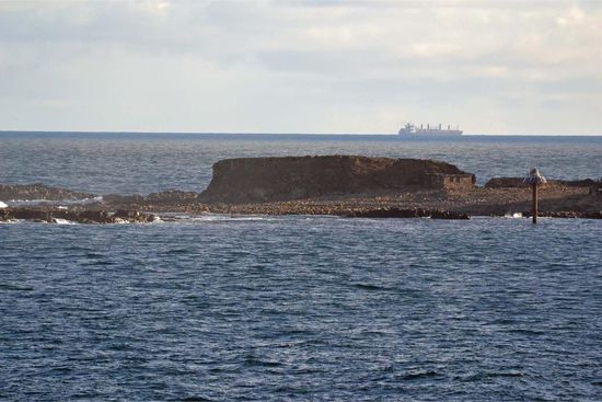 Wenn man in der Vergrößerung genau hinschaut, dann kann man die Robben unscharf erkennen (die Flecken am Strand vor dem Felsen). Leider war diese Insel zuweit weg, um bessere Fotos zu machen. 