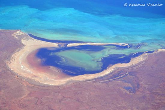 Ein Blick auf das Farbspiel bei "Monky Mia" - rote Erde trifft auf weißen Sand und dann auf das blaue Wasser....