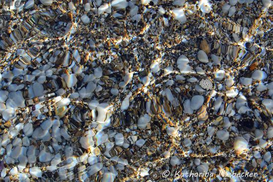 Kristallklares Wasser am etwas steinigen, aber schönen Strand.