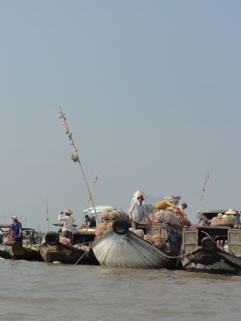 Floating Market. Das Angebot des jeweiligen Bootes wird an der Bambusstange aufgehaengt.