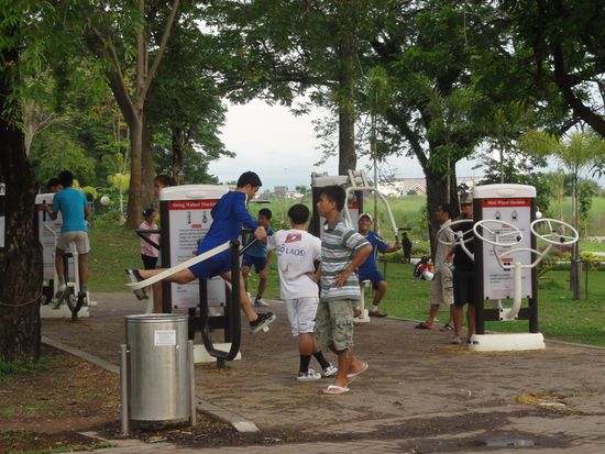In Laos wird die Volksgesundheit aktiv gefoerdert. Im Stadtpark sind oeffentliche Fitnessgeraete aufgestellt. Ab 17 Uhr herrscht hier ein reges Kommen und Gehen...