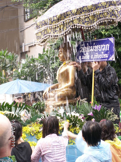 Prächtig geschmückte Wagen mit Buddhafiguren ziehen am Nachmittag in einer Parade durch die Stadt.