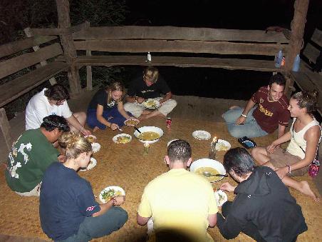 Gemuetliches Abendessen am Boden einer Dschungelhuette