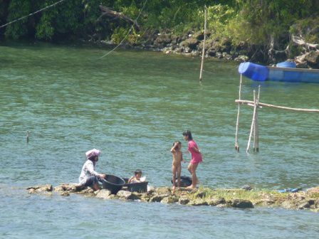 Den ganzen Tag über sieht man auf der ganzen Insel Frauen, die Wäsche, Geschirr oder ihre Kinder im See waschen. Im Hintergrund ein Plaste-Tonnen-Boot.
