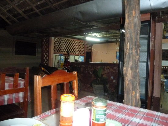 hinter der Blume befindet sich die Küche und dahinter dann das Wohnhaus, typisch für Laos