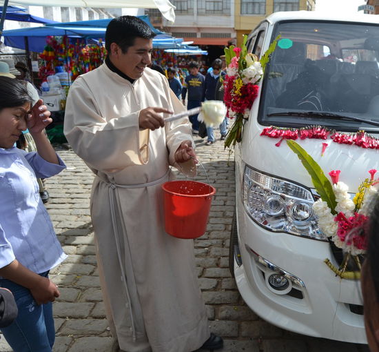 An jedem Wochenende kommen hier Familien aus ganz Bolivien und dem angrenzenden Peru und lassen ihre Autos segnen. Der Segen wird sowohl von einem Mönch als auch einem Schamanen erteilt.