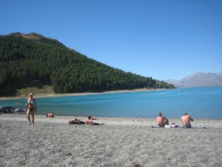 Lake Tekapo mit ein paar Leuten am Strand.