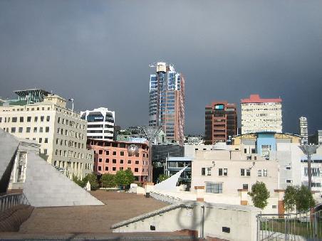 Civic Square mit Haeusern und dunklen Wolken, aber auch ein bisschen Sonne.