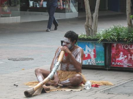 Aborigine spielt Digeridoo.