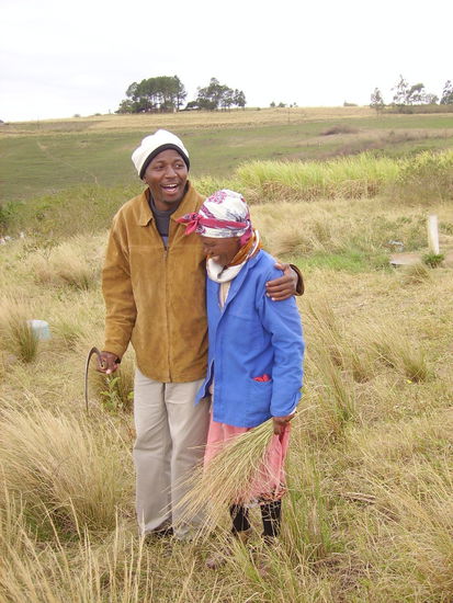 unser guide mit einer village frau. die sammelt das gras um das fuer ein dach zu benutzen.