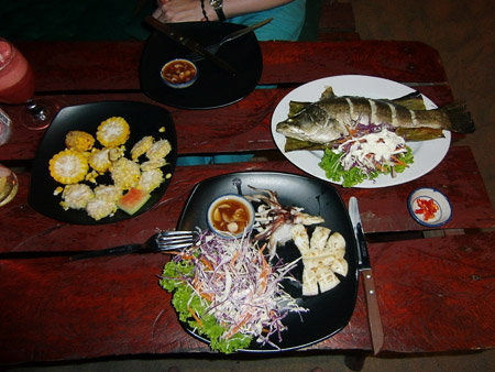 Fisch im Banenblatt, gegrillter Tintenfisch und ein Maiskolben