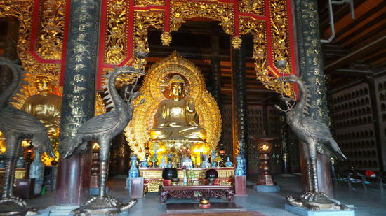 im Tempel sitzen die großen goldenen Buddhas