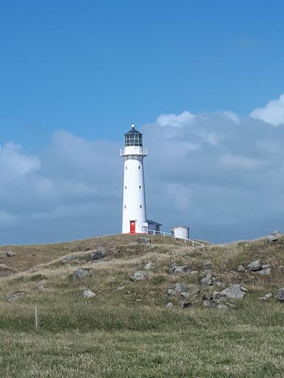 Leuchtturm von Cape Egmont, im Hintergrund kaum zu erahnen der Mount Taranaki