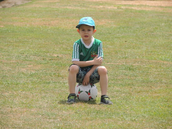 ... mit einem Fussball am Rasen ...