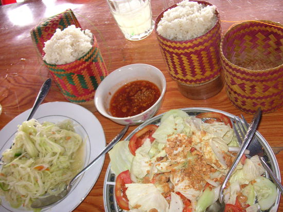Typisches laotisches Essen fuer Vegetarier: Im Hintergrund STICKY RICE, dazu Chilly Sauce, Papaya Salad und Laos Salad...