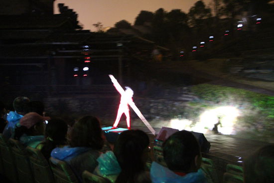Die Zuschauertribühne lasst sich um 360 Grad drehen. Es sieht so aus als würden die Zuschauer mit einem Bambusstock wie eines der Bambusboote in Wuyishan weiterbewegt.
