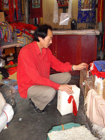 mein Schneider mit meinem eingenähten Packerl, das gerade versiegelt wird.