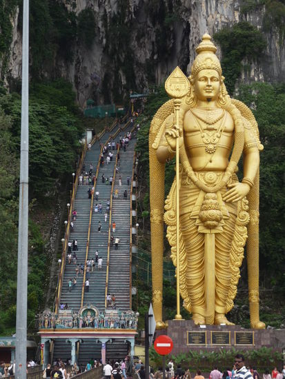 Die Statue an Eingang und dahinter der Weg zu den Höhlen