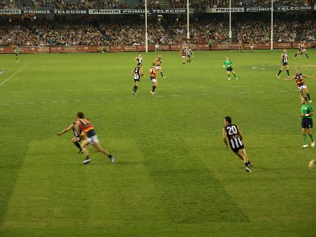 Collingwood sind die schwarz-weiss gestreiften, Adelaide die rot-gelb-schwarzen. Ein Spiel dauert 4 mal 20 Minuten (reine Spielzeit). Es gibt sechs Punkte, wenn man den Ball durch die mittleren zwei Stangen kickt und einen, wenn man ins rechte oder linke Tor bzw. an den Pfosten schiesst.