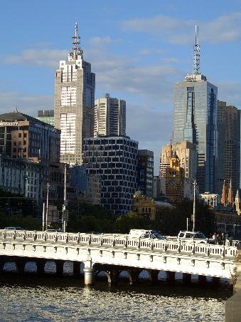 Blick auf die Flinders Street Station, das gelbe Gebaeude mit der Uhr, und dem Fluss Yarra