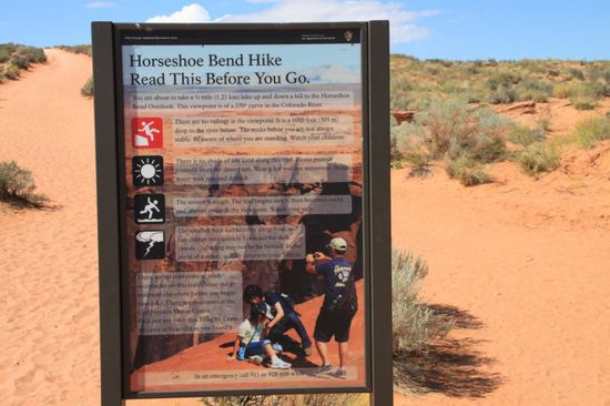 Das zweite Ziel für heute ist der Horseshoe Bend - ebenfalls eine traumhafte Stelle.
Es handelt sich um einen gigantischen Fels der von der Form her tatsächlich einem Pferdefuß ähnelt.
Drumherm fließt in einer Schleife der Colorado River.
Leider ist der Weg dahin recht beschwerlich, es geht durch tiefen Sand bergauf.
Im Hintergrund links hinter dem Schild kann man das erste Stück des Weges gut erkennen, es geht nach dem Hügel dann noch weiter.