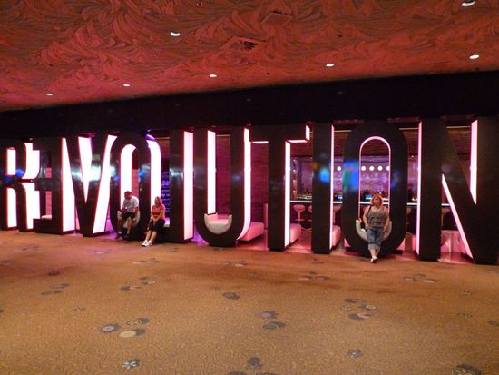 Nach der Show gehen wir ins Mirage, essen noch einen völlig überteuerten Burger weil das Buffet leider schon geschlossen hatte, verzockten an einer Slot-Machine noch 10 Dollar - wir sind halt nicht so die Spieler und gingen zurück in unser Zimmer.
Alles ist so weit auseinander in Las Vegas und es sind unfassbar lange Wege zurückzulegen.
Erwähnte ich schon dass uns die unteren Gliedmaßen dermaßen schmerzten dass wir kaum noch gehen konnten?
Hier entspanne ich mich kurz in den "Revolution"-Buchstaben (origineller Eingang zur Beatles-Show die im Mirage läuft) auf dem Weg zum Fahrstuhl der uns nach oben bringt.
Wir wollen nur noch ins Bett - morgen haben wir wieder viel vor!