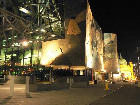 der Federation Square bei Nacht, dahinter die Flinders Station