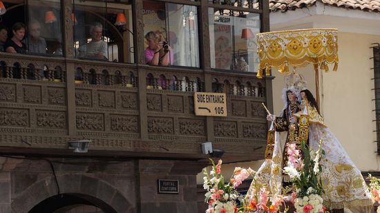 ...begleitet die Jungfrau auf ihrem Zug durch die Stadt, vorbei an unglaeubig dreinschauenden Touristen