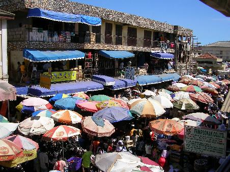 Eine Straße des Makola-Markets. Zwischen den Marktgebäuden drängen sich die Händler auf der Straße, zwischen ihnen drängen sich die Kunden. Ein hektischer Ort.