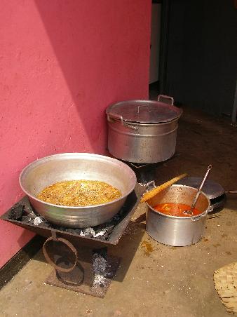 In der "Fritteuse" brutzeln Hühnerteile, dahinter kocht die Suppe.