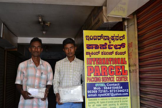 Ein prosperierendes Business. Vater und Sohn versenden fuer Pakete in alle Welt.