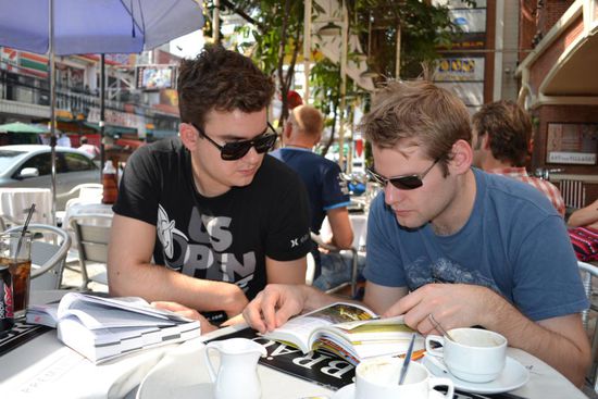 Martin und Philipp studieren die Reiseroute bzw. schauen die farbenfrohen Bilder des Reiseführers an.