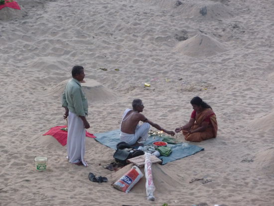 Varkala: Priester gibt seinen Segen den Verbliebenen des Toten. Die Asche wird, glaube ich, unter den Sandhaufen gelegt.