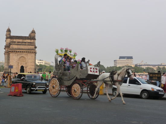Gate of India im Hintergrund, reiche indische Touristen im Vordergrund.