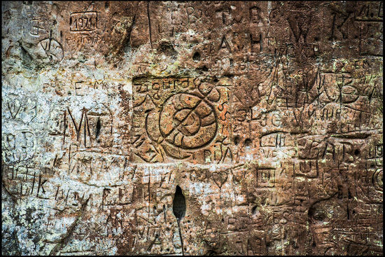 Inschriften und Einritzungen im weichen Sandstein.