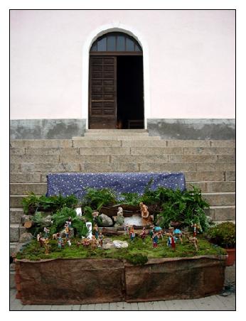 Eine vor der Kirche aufgebaute Krippe mit fehlendem Jesuskind.