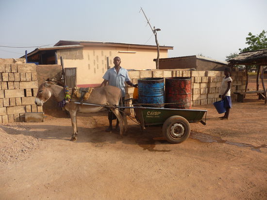 Wasserlieferung vor dem Haus meiner Gastfamilie. Vor dem Haus liegen Steine, die diese Woche produziert wurden aus Sand und Zement.