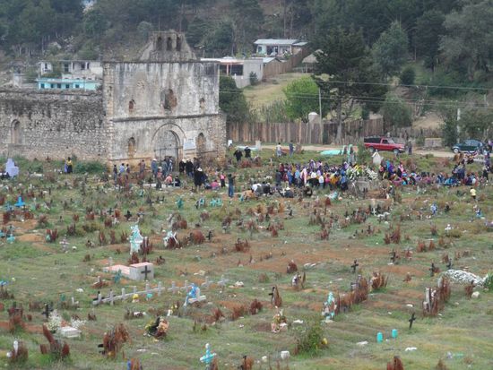 Die unterschiedlichen Farben der Kreuze auf dem Friedhof stehen fuer das Alter der Person (Schwarze Kreuze für alte Menschen, weisse Kreuze für junge Menschen und blaue Kreuze fuer alle uerbrigen Personen)