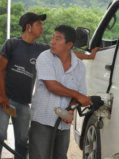 Was macht 
A) der hintere Typ der eine Hand am Bus hat und
B) der vordere Typ mit der Plastikflasche?