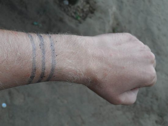 Maenner malen sich i.d.R. drei schwarze Linien auf die Haut. Die Linien sind ein Symbol fuer den Weg, da die Tsachilas eigentlich immer auf Wanderschaft waren. Damals war es keine Seltenheit das sie 8 Tage zu Fuss nach Quito gegangen sind um dort ihre Waren zu verkaufen. Heute nehmen sie den Bus.