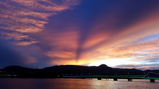 Fluss Theuk Chhou mit Blick auf die beleuchtete "Old Bridge" von Kampot.