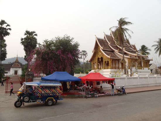 Ho Phra Bang vor dem Palastmuseum mit den typischen Tuk Tuk und Marktständen.
