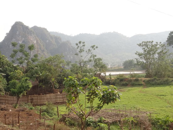 Ausblick in Vieng Xai zum kleinen See neben dem Dorf und im Hintergrund wieder die Berge.