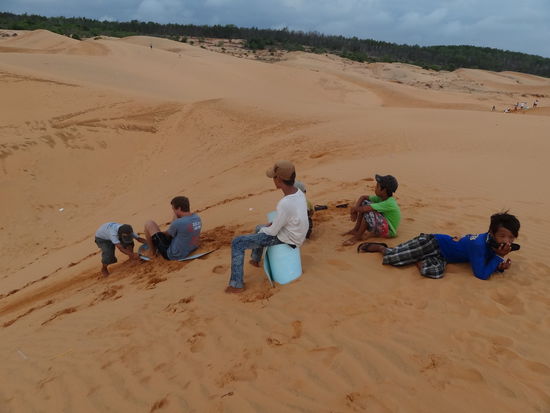 Sanddünenschlitteln. Natürlich wollen die Kids ein kleines Entgeld für ihre Schlittelhilfe.