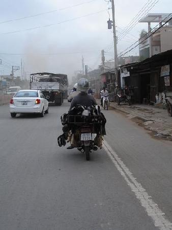 ...die Strasse von My Tho nach Saigon...hier heisst's 70 km lang Staub und Abgase schlucken...das gilt ebenso fuer die 5 Ziegen auf dem Motorrad vor uns...